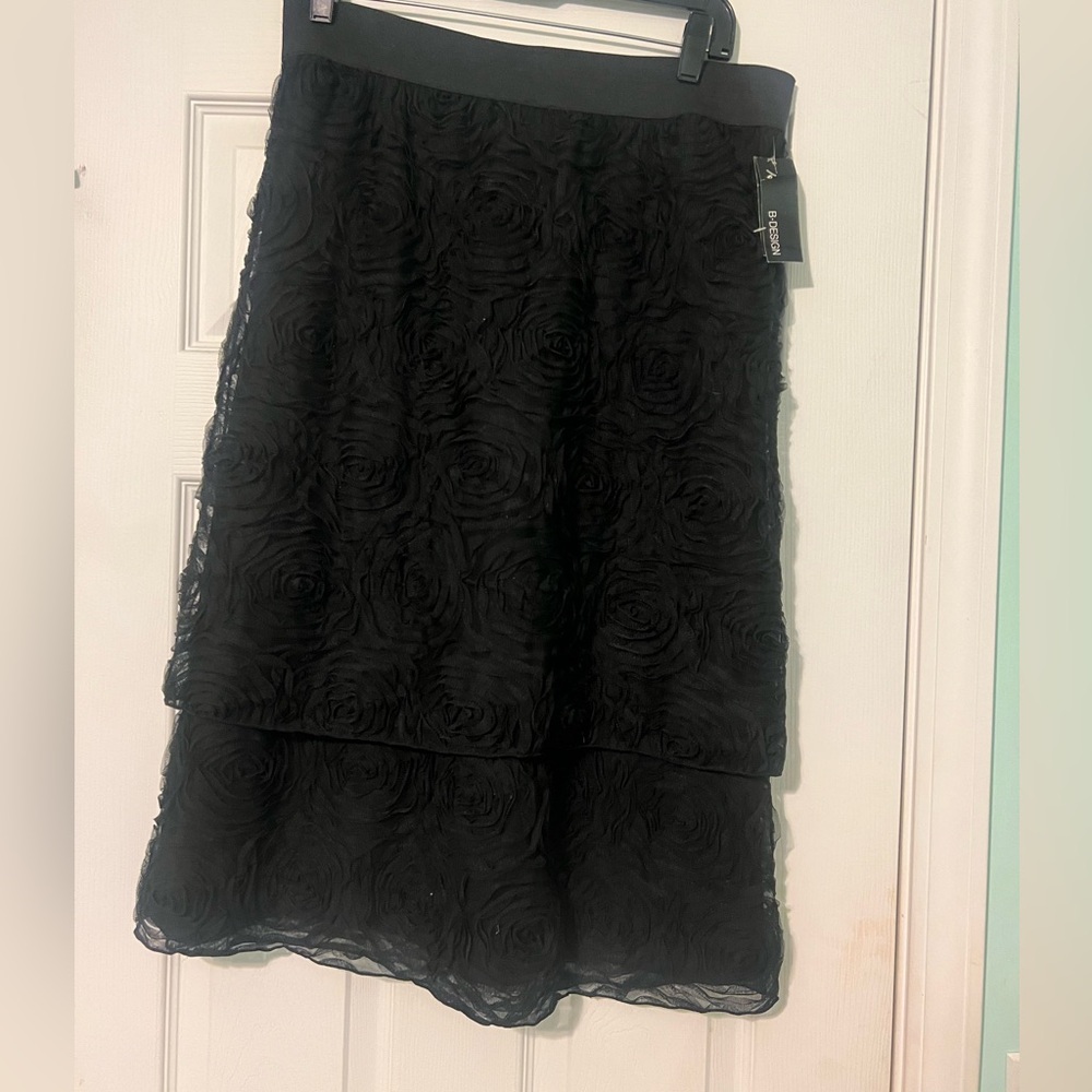 This is a black tulle or chiffon skirt with 3D floral rosettes.